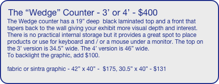 The “Wedge” Counter - 3’ or 4’ - $400
The Wedge counter has a 19” deep  black laminated top and a front that tapers back to the wall giving your exhibit more visual depth and interest. There is no practical internal storage but it provides a great spot to place products or use for keyboard and / or a mouse under a monitor. The top on the 3’ version is 34.5” wide. The 4’ version is 46” wide.
To backlight the graphic, add $100.

fabric or sintra graphic - 42” x 40” -  $175, 30.5” x 40” - $131